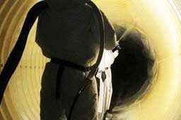 Workers spraying inside of steel tubing